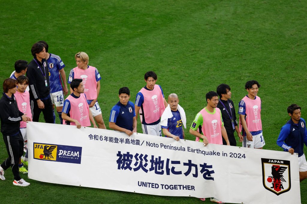 日本球员赛后拉起横幅，为日本能登半岛地震的灾民打气。——照片：路透社