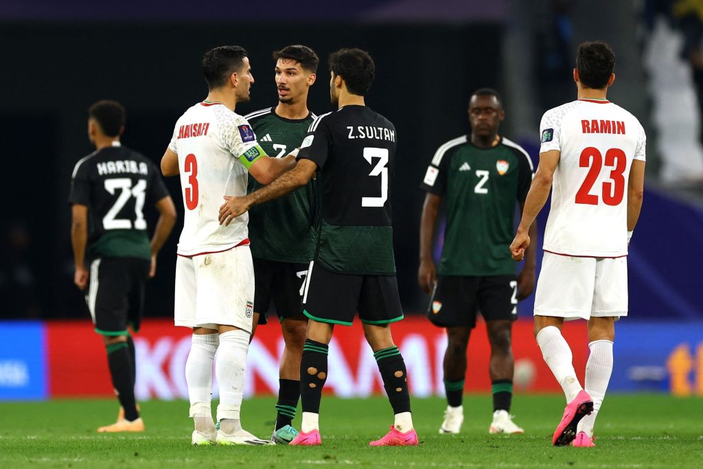 虽然输了比赛，但阿联酋仍保住小组第二，阿联酋球员（黑色球衣）赛后与对手握手致意。——照片：路透社