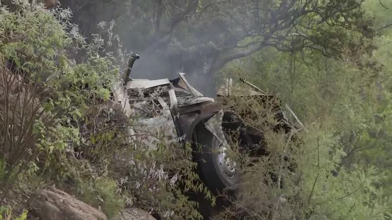 巴士坠入山谷后起火燃烧，车体毁不成形。——照片：路透社